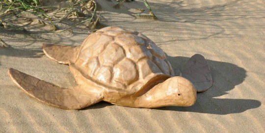 De grote biologisch afbreekbare Schildpad-urn op het strand van Scheveningen, voor een asbijzetting in het water.